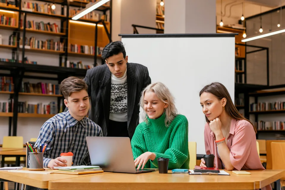 Students working together around a laptop